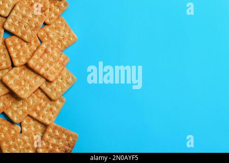 Delicious crackers on light blue background, flat lay. Space for text Stock Photo