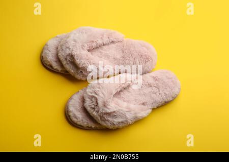 Pair of stylish soft slippers on yellow background Stock Photo