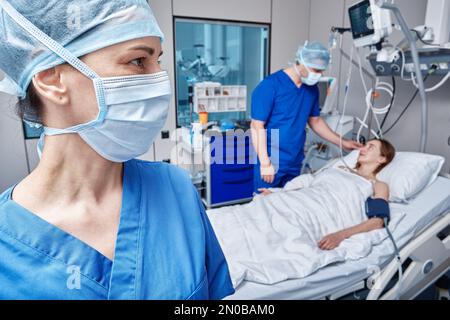 Intensive care unit. doctor and nurse caring for female patient in emergency care unit of hospital Stock Photo