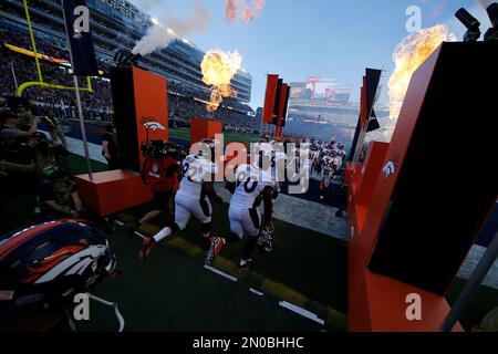 Denver Broncos players run on the field led by McTelvin Agim (95), Marquiss  Spencer (51), Justin Strnad (40), Jamar Johnson (41) with other following  to start an NFL football preseason game against