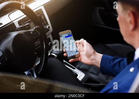 businessman in suit working with project statistics, graph and diagram on phone screen, entrepreneur accountant analysing financial data while sitting Stock Photo