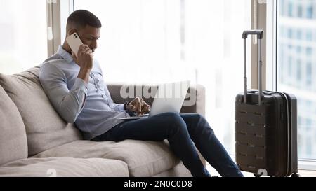 Busy young millennial travelling business man using digital gadgets Stock Photo
