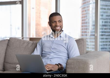 Happy attractive young businessman working on online freelance project Stock Photo