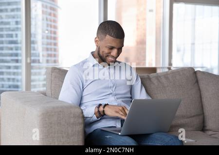 Cheerful busy African freelance entrepreneur man working from home Stock Photo