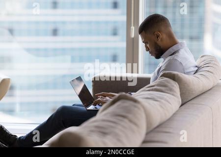 Busy focused young business man working at home, using laptop Stock Photo