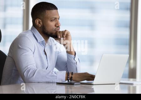 Thoughtful young African office worker thinking over career problems Stock Photo