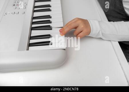 Children's hands on the keys of the synthesizer. Stock Photo