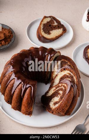Chocolate marble bundt cake or zebra cake with chocolate glaze drizzled sliced on a plate Stock Photo