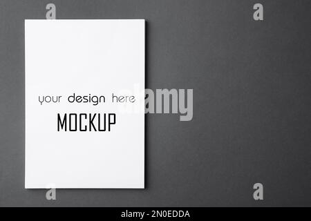 Paper sheet with text Mockup Your Design Here on dark grey background, top view Stock Photo
