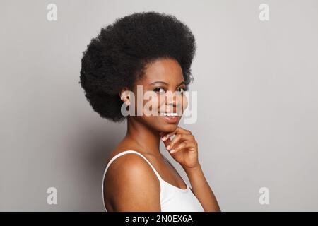 Beautiful smiling lady. Brunette woman with healthy smile and dark curly hairstyle Stock Photo