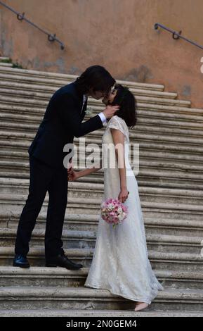 A happy married couple kiss on a flight of steps beside the Palazzo dei Conservatori, Capitol Hill, Rome, Italy, Europe. Stock Photo