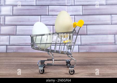 Green and blue farm fresh eggs in a tiny shopping cart Stock Photo