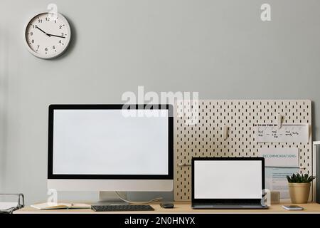 Minimal front view office workplace setup with two screen mockups on desk, copy space Stock Photo