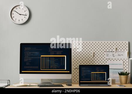 Front view office workplace setup with computer code on two screens, copy space Stock Photo