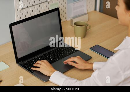 High angle closeup of young woman typing at laptop keyboard while working from home office Stock Photo