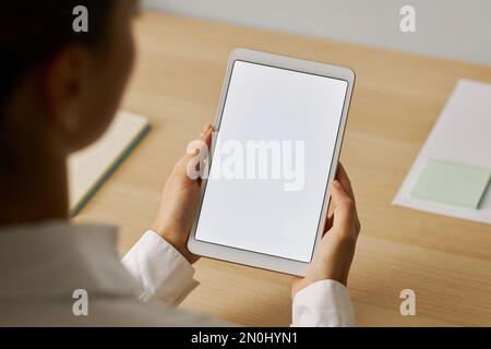 Minimal closeup of young woman holding digital tablet with white screen mockup at workplace Stock Photo