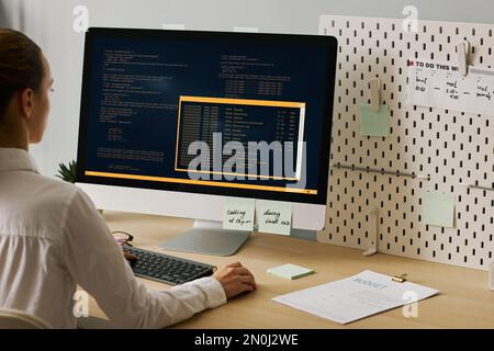 Close up of young woman using computer and writing code while working at desk, copy space Stock Photo