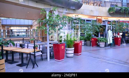 Warsaw, Poland. 27 October 2020. Wide angle view of empty food court at Zlote Tarasy shopping mall. Customers are not allowed to dine-in, Stock Photo