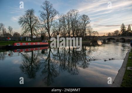 Reflections on the River Thames, with Wallingford Bridge and a red canal boat on the water. Stock Photo