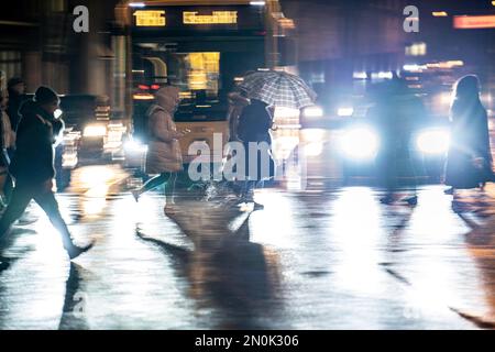 Passers-by at a pedestrian crossing, at the main station, rainy weather, city centre, in the evening, Essen, NRW, Germany, Stock Photo