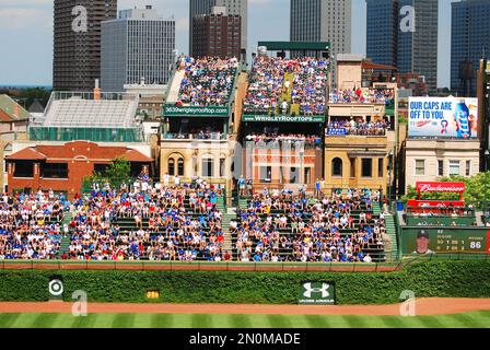 SPORTS Chicago Illinois Night game at Wrigley Field fans in bleachers  traditional scoreboard ivy on outfield wall Stock Photo - Alamy