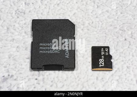 Top view of microSD memory card with SD adapter against mottled gray background. Stock Photo