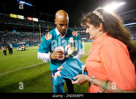 Former Miami Dolphins player Jason Taylor goes to kiss his wife, Katina, as  he and Zach Thomas are inducted into the Dolphins' Ring of Honor during  halftime of the game between the