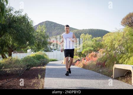 A young runner runs in a public park, sports and wellness concept Stock Photo