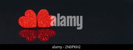 Two red hearts with reflection on black background. Valentines day concept. Copy space. Stock Photo
