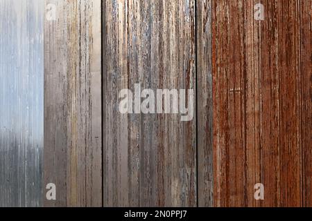 Weathered metal surface showing rust and aging texture in multi-colored stripes Stock Photo