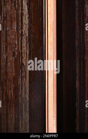 Weathered metal surface showing rust and aging texture in multi-colored stripes in vertical format Stock Photo