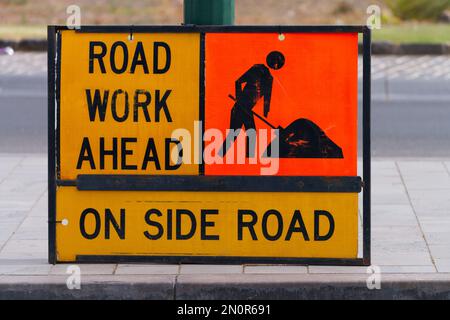 Road work ahead sign indicating construction on side road in Melbourne Australia.