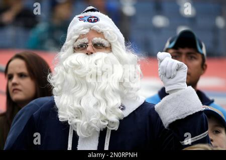 A Tennessee Titans fan dressed as Santa Claus holds his beer as he cheers  in the first quarter of an NFL football game against the St. Louis Rams on  Sunday, Dec. 13