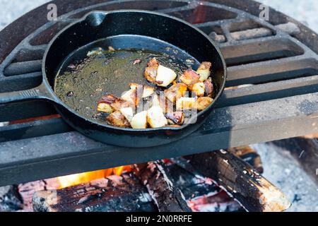 https://l450v.alamy.com/450v/2n0rrfe/cooking-fried-potato-hashbrowns-in-a-cast-iron-skillet-over-a-campfire-2n0rrfe.jpg