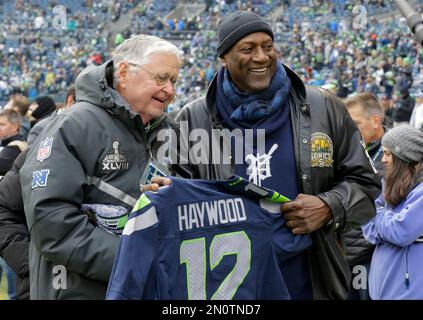 Spencer Haywood, right, former Seattle SuperSonics player, pulls the rope  to hoist his jersey, along with other retired Sonics jerseys into the  rafters at KeyArena at halftime of an NBA basketball game