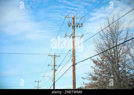 Electric power lines in the clear blue sky Stock Photo