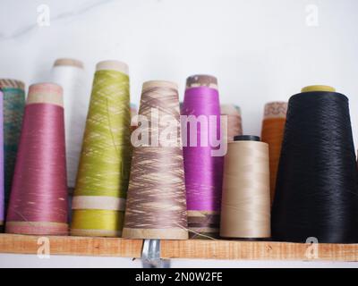 Multicolor sewing threads on wooden background.Color sewing threads on white background, top view Stock Photo