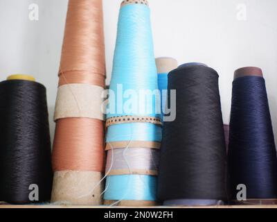 Multicolor sewing threads on wooden background.Color sewing threads on white background, top view Stock Photo