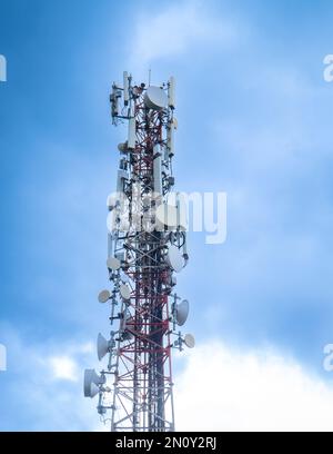 Telecommunication tower with blue and white clouds sky. Copy space. Stock Photo