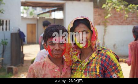 Outdoor image of Asian, Indian happy mother son in Indian dress celebrating the Holi festival together with color powder. Stock Photo