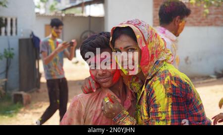 Outdoor image of Asian, Indian happy mother son in Indian dress celebrating the Holi festival together with color powder. Stock Photo