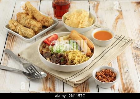 Soto Mie Bogor, Indonesian Traditional Beef Noodle Soup from West Java with Yellow Noodles, Rice Noodle, Beef, Spring Roll, Cabbage, and Sliced Tomato Stock Photo