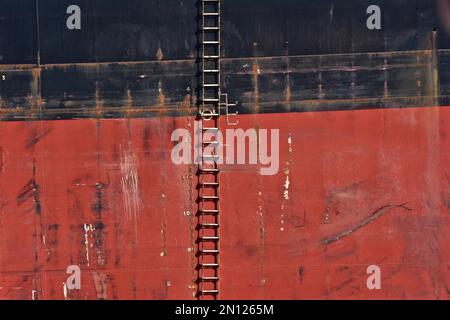 Rope ladder on the red and black side of a freighter Stock Photo