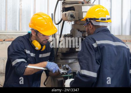 Engineer man training with foreman for apprentice using lathe, apprenticeship teaching with worker, technician and learning, inspector and labor, inte Stock Photo