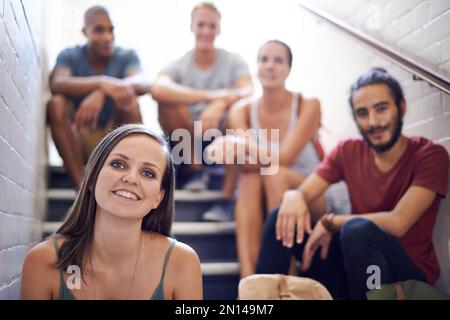 Relaxing before class. university students sitting on the steps of a staircase. Stock Photo