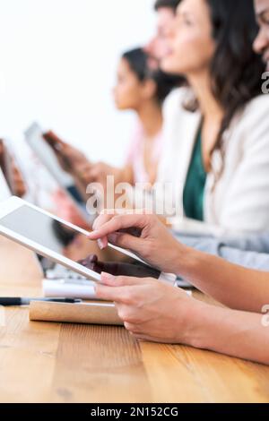 Wireless freedom in the boardroom. a group of businesspeople using their wireless devices during a meeting. Stock Photo