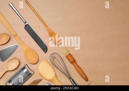 Set of modern cooking utensils on brown background, flat lay. Space for text Stock Photo