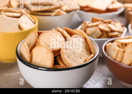 Delicious crackers in bowls on table, closeup Stock Photo