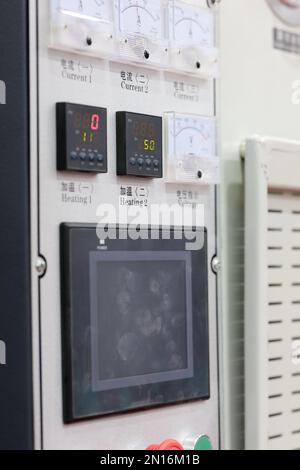 Modern industrial control panel with touch screen, analog gauges, digital temperature controllers. Selective focus. Stock Photo