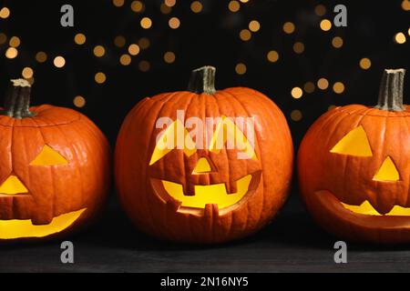 Pumpkin jack o'lanterns on table against blurred background. Halloween decor Stock Photo